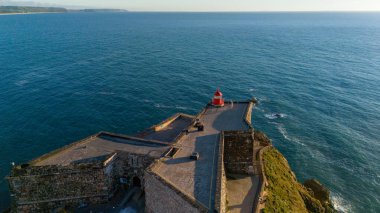 Kırmızı deniz feneri lamba Oda Nazare, Portekiz mavi gökyüzü ve denizin arka plan üzerinde