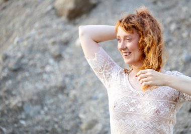 Kayalık arazide poz veren etkileyici kadın.