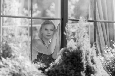 Pencerenin Arkasında Düşünceli, Üzgün, Hafif Doğal Işıkta Bir Kadın Portresi