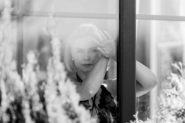 Pencerenin Arkasında Düşünceli, Üzgün, Hafif Doğal Işıkta Bir Kadın Portresi