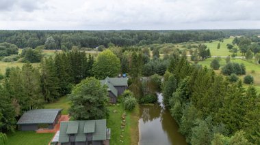 Sventoji, Palanga, Litvanya yakınlarındaki Zelv Village SPA 'nın hava manzarası. Ahşap kulübeler, göl ve modern spa tesisleri ve spor alanları olan orman çevreleri. 07 29 2025