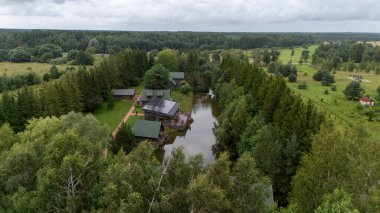 Sventoji, Palanga, Litvanya yakınlarındaki Zelv Village SPA 'nın hava manzarası. Ahşap kulübeler, göl ve modern spa tesisleri ve spor alanları olan orman çevreleri. 07 29 2025