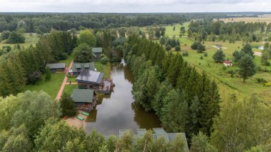 Sventoji, Palanga, Litvanya yakınlarındaki Zelv Village SPA 'nın hava manzarası. Ahşap kulübeler, göl ve modern spa tesisleri ve spor alanları olan orman çevreleri. 07 29 2025