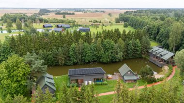 Sventoji, Palanga, Litvanya yakınlarındaki Zelv Village SPA 'nın hava manzarası. Ahşap kulübeler, göl ve modern spa tesisleri ve spor alanları olan orman çevreleri. 07 29 2025