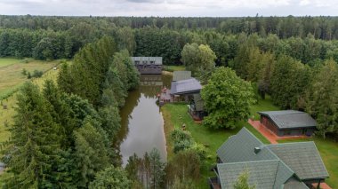 Sventoji, Palanga, Litvanya yakınlarındaki Zelv Village SPA 'nın hava manzarası. Ahşap kulübeler, göl ve modern spa tesisleri ve spor alanları olan orman çevreleri. 07 29 2025