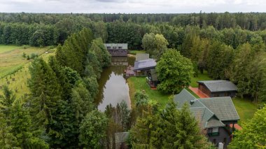 Sventoji, Palanga, Litvanya yakınlarındaki Zelv Village SPA 'nın hava manzarası. Ahşap kulübeler, göl ve modern spa tesisleri ve spor alanları olan orman çevreleri. 07 29 2025