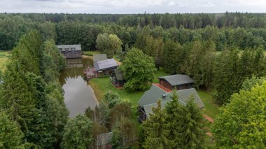 Sventoji, Palanga, Litvanya yakınlarındaki Zelv Village SPA 'nın hava manzarası. Ahşap kulübeler, göl ve modern spa tesisleri ve spor alanları olan orman çevreleri. 07 29 2025