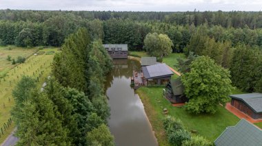 Sventoji, Palanga, Litvanya yakınlarındaki Zelv Village SPA 'nın hava manzarası. Ahşap kulübeler, göl ve modern spa tesisleri ve spor alanları olan orman çevreleri. 07 29 2025