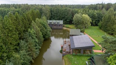 Sventoji, Palanga, Litvanya yakınlarındaki Zelv Village SPA 'nın hava manzarası. Ahşap kulübeler, göl ve modern spa tesisleri ve spor alanları olan orman çevreleri. 07 29 2025