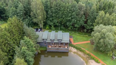 Sventoji, Palanga, Litvanya yakınlarındaki Zelv Village SPA 'nın hava manzarası. Ahşap kulübeler, göl ve modern spa tesisleri ve spor alanları olan orman çevreleri. 07 29 2025