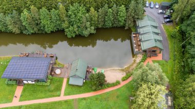 Sventoji, Palanga, Litvanya yakınlarındaki Zelv Village SPA 'nın hava manzarası. Ahşap kulübeler, göl ve modern spa tesisleri ve spor alanları olan orman çevreleri. 07 29 2025