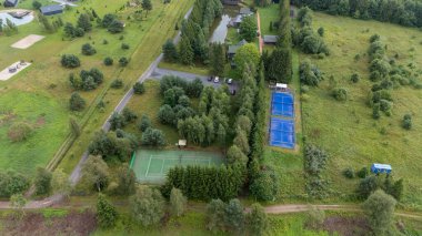 Sventoji, Palanga, Litvanya yakınlarındaki Zelv Village SPA 'nın hava manzarası. Ahşap kulübeler, göl ve modern spa tesisleri ve spor alanları olan orman çevreleri. 07 29 2025