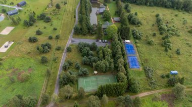 Sventoji, Palanga, Litvanya yakınlarındaki Zelv Village SPA 'nın hava manzarası. Ahşap kulübeler, göl ve modern spa tesisleri ve spor alanları olan orman çevreleri. 07 29 2025