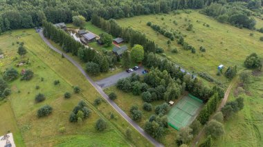 Sventoji, Palanga, Litvanya yakınlarındaki Zelv Village SPA 'nın hava manzarası. Ahşap kulübeler, göl ve modern spa tesisleri ve spor alanları olan orman çevreleri. 07 29 2025