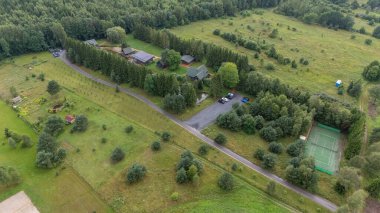 Sventoji, Palanga, Litvanya yakınlarındaki Zelv Village SPA 'nın hava manzarası. Ahşap kulübeler, göl ve modern spa tesisleri ve spor alanları olan orman çevreleri. 07 29 2025