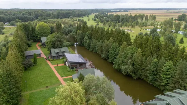 Sventoji, Palanga, Litvanya yakınlarındaki Zelv Village SPA 'nın hava manzarası. Ahşap kulübeler, göl ve modern spa tesisleri ve spor alanları olan orman çevreleri. 07 29 2025