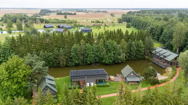 Sventoji, Palanga, Litvanya yakınlarındaki Zelv Village SPA 'nın hava manzarası. Ahşap kulübeler, göl ve modern spa tesisleri ve spor alanları olan orman çevreleri. 07 29 2025