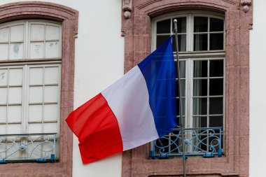 Tarihi mimarinin önünde dalgalanan üç renkli Fransız bayrağı. Fransa 'nın sembolü, vatanseverlik ve ulusal gurur. Politika, seyahat, kültür, tarih ve Avrupa temaları için mükemmel