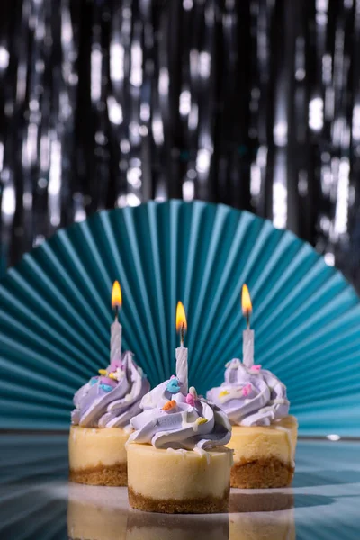 Трио Мини Чизкейков Фиолетовой Глазурью Свечами Дню Рождения Синем Фоне — стоковое фото