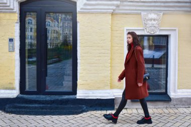 Yüzünde endişeli bir ifade olan kadın sokakta aceleyle yürüyor..