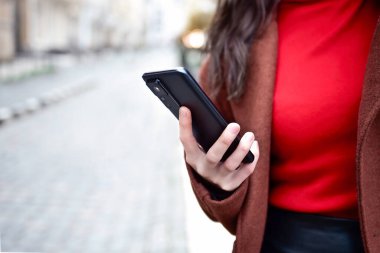 Cep telefonu bir kadının elinde. Cep telefonu elinde. Sokakta cep telefonu kullanmak..