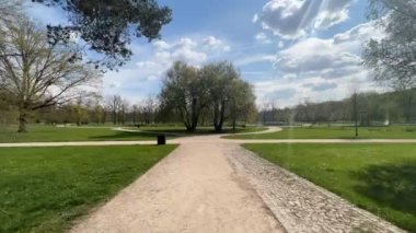 Güneşli bir bahar gününde parkta bir patika boyunca yürümenin zamanı..