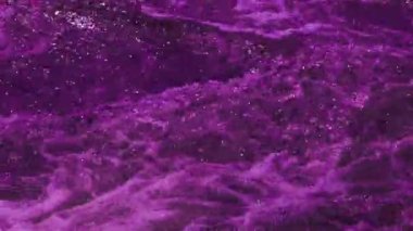 Footage of bubbling purple water and violet waves. Colorful abstract video background for good mood and meditation.