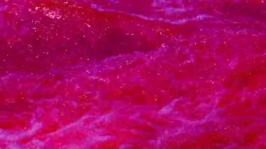 Footage of bubbling bloody water and red waves. Colorful abstract video background for good mood and meditation.