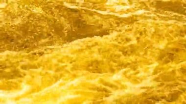 Footage of bubbling yellow water and golden waves. Colorful abstract video background for good mood and meditation.