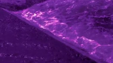 Footage of bubbling purple water and sparkling waves. Colorful abstract video background for good mood and meditation.