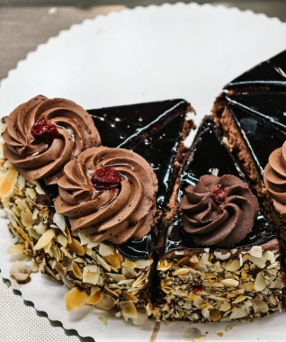 Lezzetli ve çok lezzetli çikolatalı pasta, büyük krema çiçekleri ve çikolatalı.