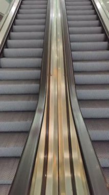 Modern alışveriş merkezlerinde ya da metro istasyonlarında yürüyen merdivenler. Kentsel arkaplan veya mimari görüntüler için simetrik kompozisyon ve minimal tasarım.