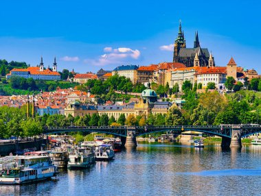 Vltava Nehri 'nde tekneli Prag Kalesi manzarası. Tarihi Mimarlık ve Seyahat ve Turizm İçin Canlı Su Yolları 'nın yer aldığı büyüleyici şehir manzarası. Stok Fotoğrafçılığı.