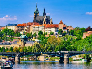Vltava Nehri 'nde tekneli Prag Kalesi manzarası. Tarihi Mimarlık ve Seyahat ve Turizm İçin Canlı Su Yolları 'nın yer aldığı büyüleyici şehir manzarası. Stok Fotoğrafçılığı.