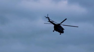 Bulutlu Mavi Gökyüzüne Karşı Askeri Helikopterin Silueti, Dramatik ve Güçlü Bir Sahne Yaratmak, Havacılık ve Askeri Temalar İçin Mükemmel. 4K video 