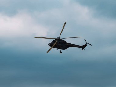 Turkuaz Gökyüzüne Karşı Uçan Bir Askeri Helikopter 'in Yan Görüntüsü, Uçağın Profilinin Detaylarını Yakalamak ve Dinamik Havacılık Sahnesi Oluşturmak