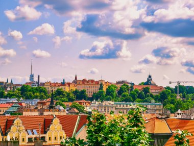 Prag 'ın Skyline' ı: Kırmızı Döşemeli Çatı ve Tarihsel Mimarinin Büyüleyici Manzarası Pofuduk Bulutlarla Parlak Mavi Gökyüzü Banyosu, Şehirlerin Eşsiz Büyüsünü Gösterme. Stok fotoğrafı 