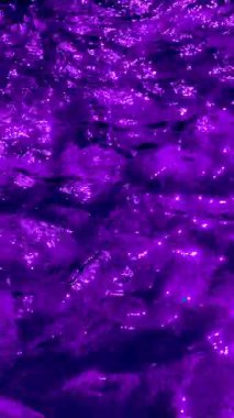 Suyun altında parlak röfleli mor kayalar. Yüksek Çözünürlüklü Özgeçmiş Duvar kağıtları, Sosyal Medya, Pazarlama ve Yaratıcı Dijital Projeler için Mükemmel. Yavaş Hareket Dikey Video 4K