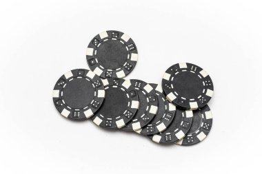 Siyah poker çiplerinin yakın plan görüntüsü beyaz arka planda düzenli bir yığın halinde, kumar, kumarhane oyunları ve bahis kavramlarını sembolize ediyor.
