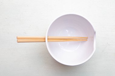 Beyaz yüzeyinde çubuklar olan minimalist kase. Yüksek kalite fotoğraf