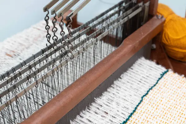 Güzelce hazırlanmış dokuma tezgahı. Tekstil işçiliğinde ve dokumada kullanılan karmaşık yapıyı vurguluyor.,