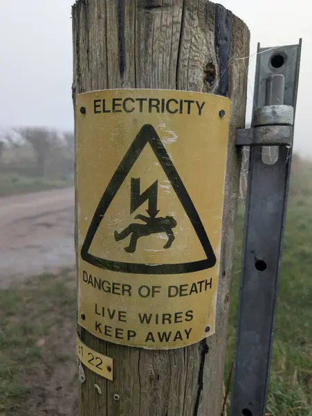 Elektrik tehlikesi. Eski sarı tabela. Yüksek kalite fotoğraf