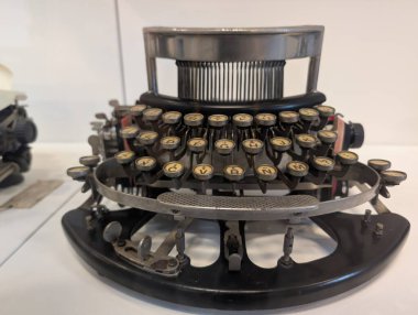 Yuvarlak tuşlu, metal çerçeveli, müze vitrinli klasik siyah daktilo. Yüksek kalite fotoğraf