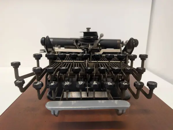 Yuvarlak tuşlu, metal çerçeveli, müze vitrinli klasik siyah daktilo. Yüksek kalite fotoğraf