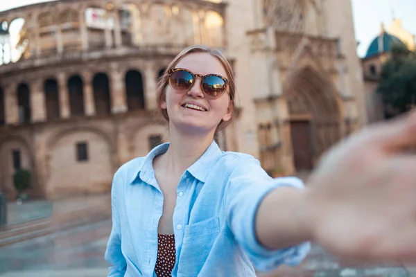 年轻乐观的女性游客戴着太阳镜 穿着时髦的衣服 在著名的瓦伦西亚大教堂前自拍自拍 高质量的照片 — 图库照片