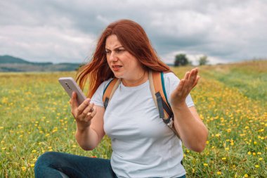 Sinyal şebekesi yok. İletişim kapsama alanı yok, iletişim sinyali yok. Kızgın kadın turist, elinde akıllı telefon arama sinyali tutuyor. İletişim, hücresel sorun, kötü bağlantı.