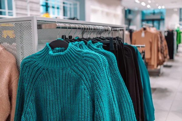 Hafif arka planda gardırop askısında sıcak süveterler. Sonbahar, kış giysileri. Alışveriş mağazası. Gdansk, Polonya, Avrupa. 