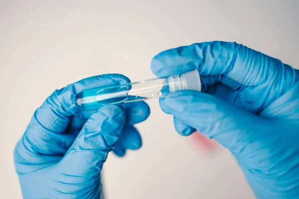 stock image Doctor with surgical mask holding a blood sample. Researchers are inventing vaccines to treat COVID-19 virus. 