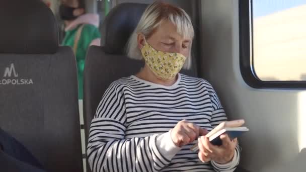 Μια Όμορφη 50Άρα Γυναίκα Ταξιδιώτης Φοράει Μάσκα Προσώπου Ταξιδεύοντας Τρένο — Αρχείο Βίντεο
