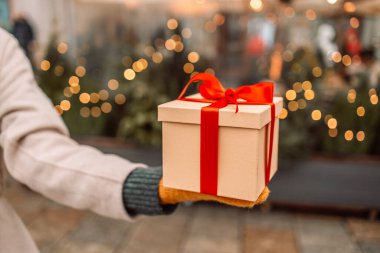 Yakın çekim, sürpriz hediye kutusu, kırmızı kurdeleli hediye paketi verir. Doğum günü Noel konsepti 
